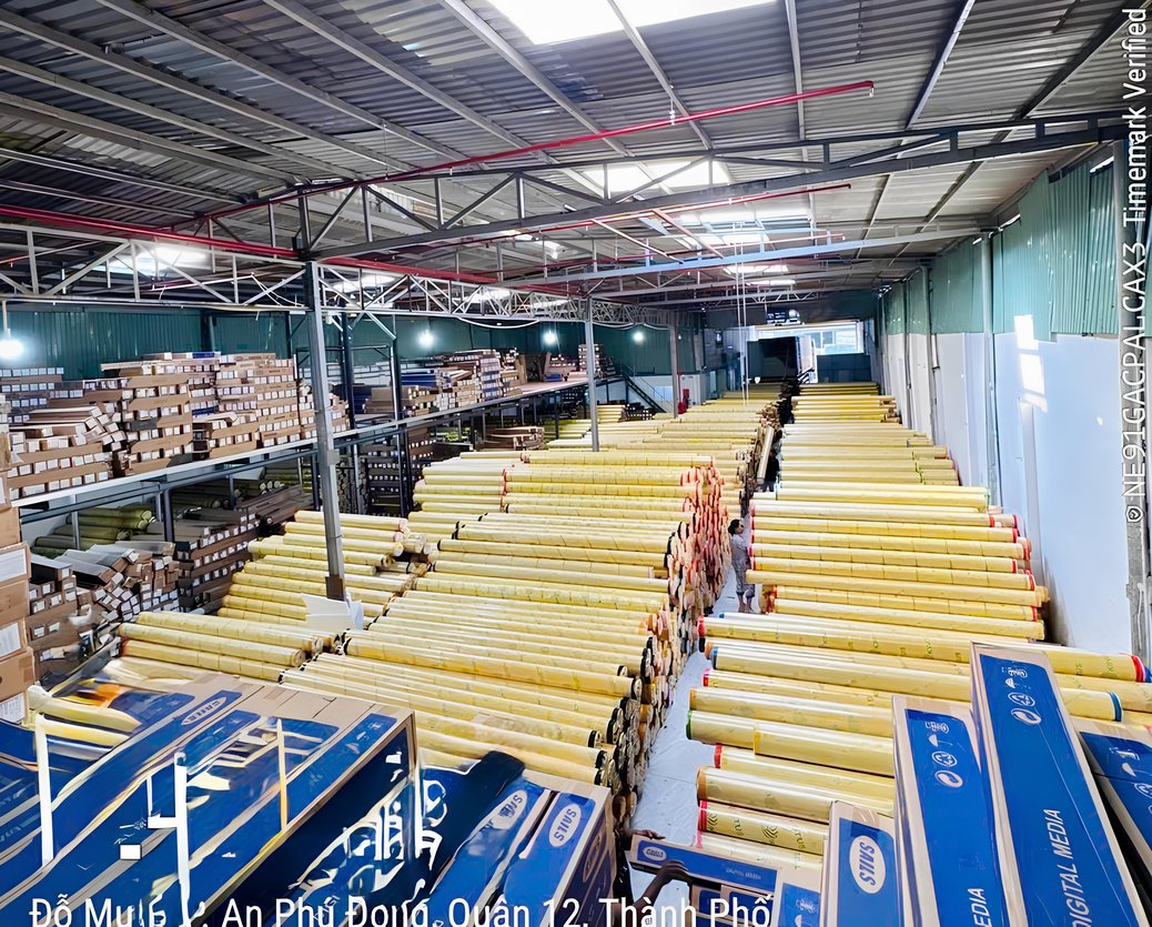 Kho xưởng thực tế của Vạn Hưng với các cuộn vật tư quảng cáo được sắp xếp theo lô